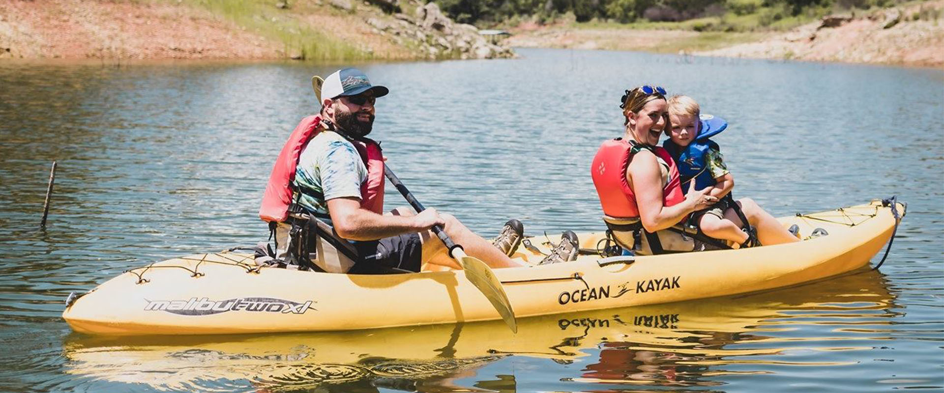 Hombre, mujer y niño en un kayak en un río